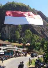 Bendera Raksasa Merah Putih Terbentang di Tebing Batu Numpang