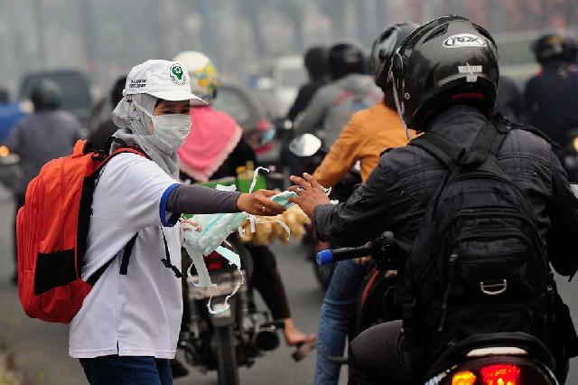 Antisipasi ISPA, Petugas Bagikan Masker ke Pemotor 